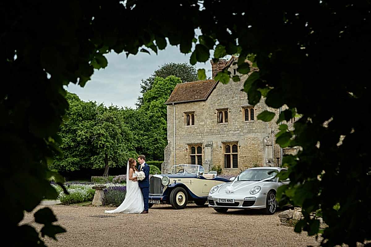 Bride and groom with their wedding cars at Notley Abbey