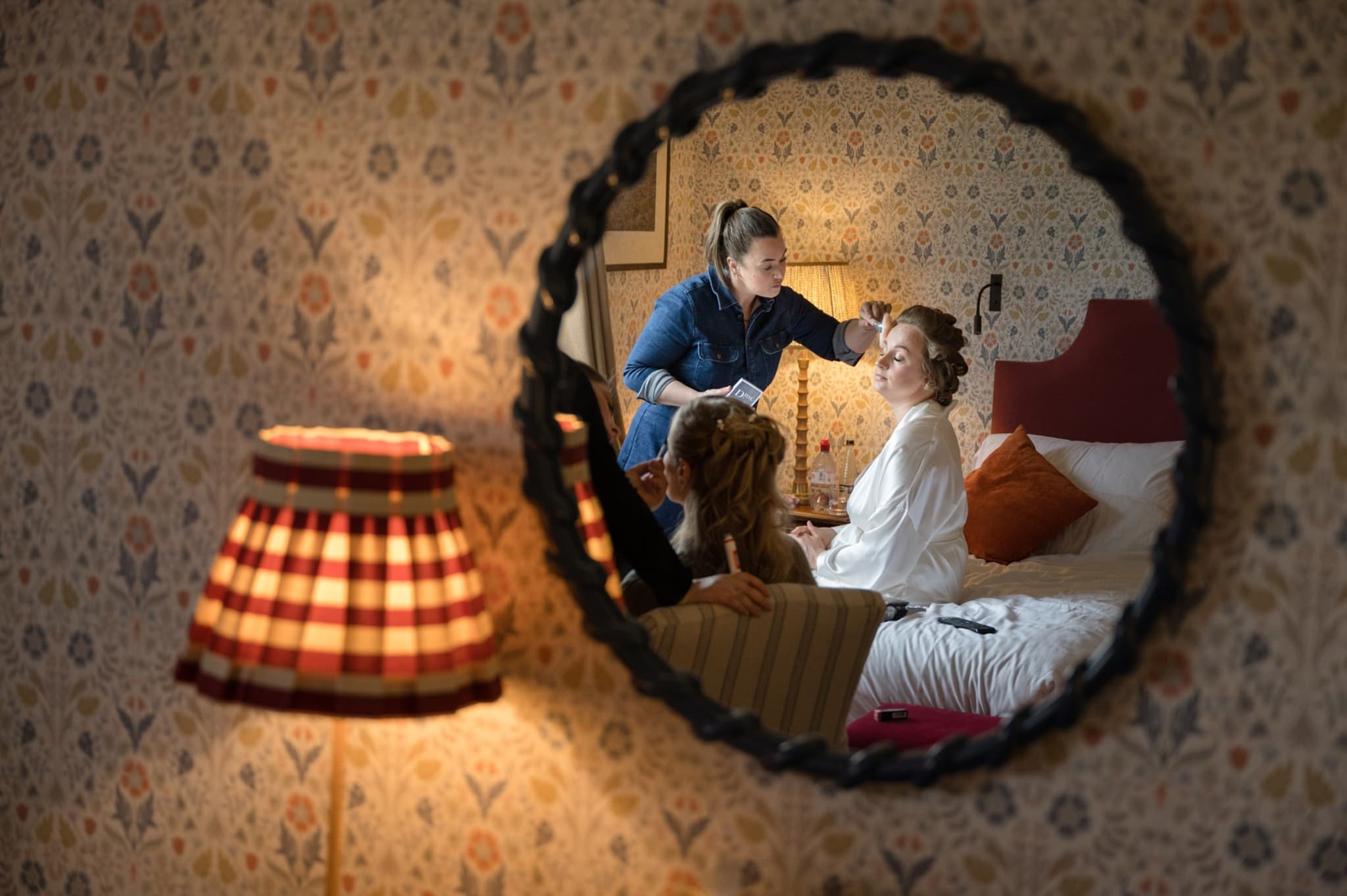 Reflection in a mirror of the bride having her makeup done at The Barnsdale hotel