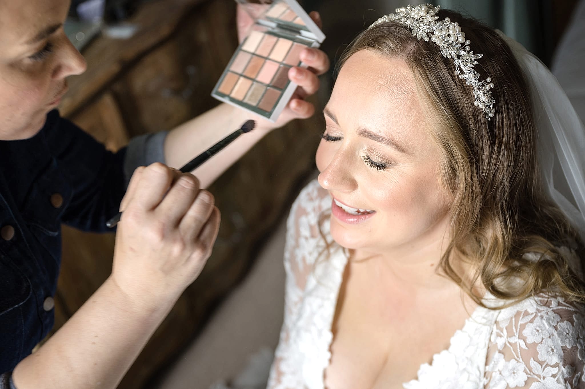 A makeup artist add the final touches to the bride's eyeshadow