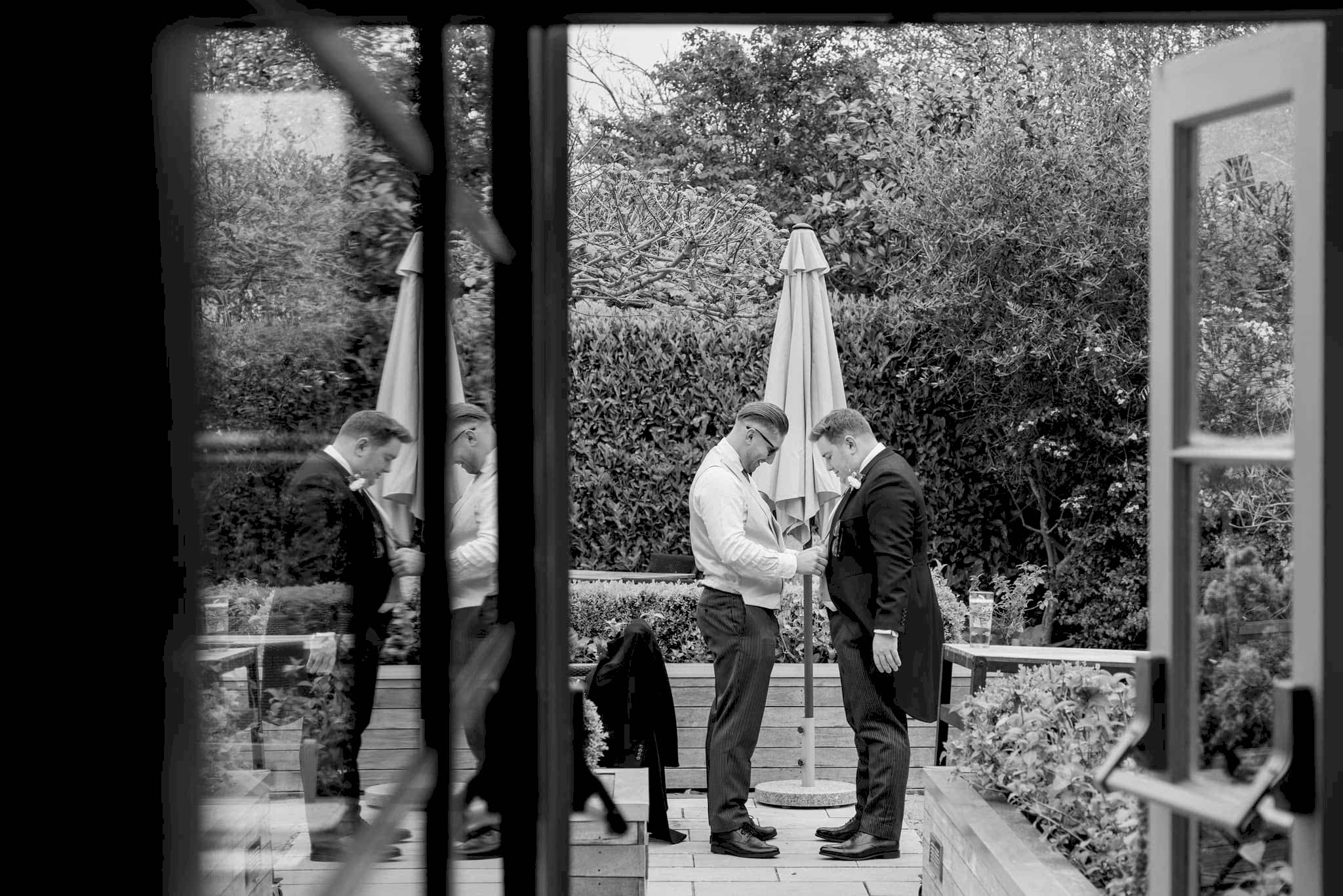 An usher helping the groom with his jacket