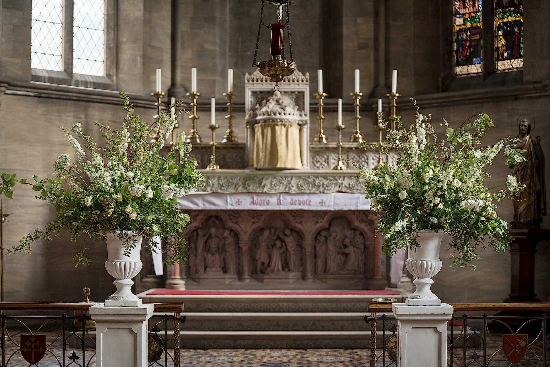 Two symmetrical urns of fresh flowers on the altar at Exton Park chapel