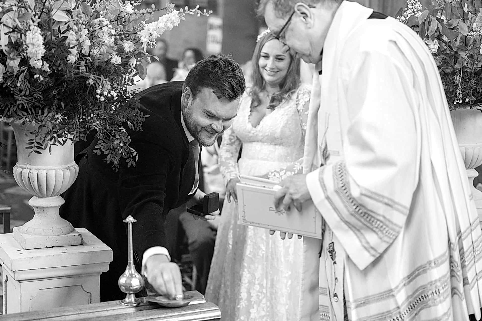 Groom placing the couple's wedding rings in a dish during the marriage ceremony