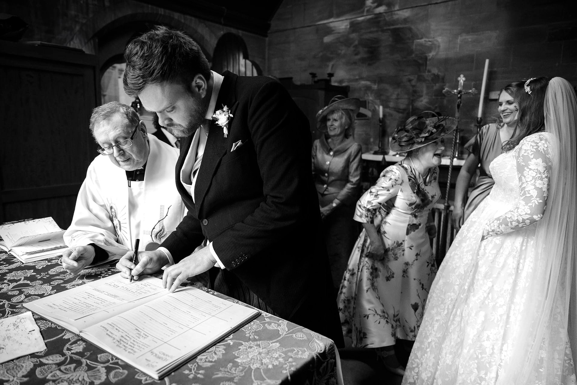 The best man signing the marriage register at Exton Park chapel