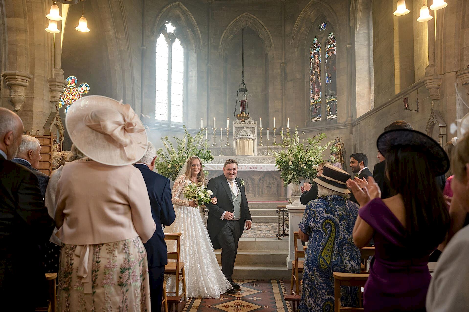 Bride and groom walking down the aisle at Exton Park chapel