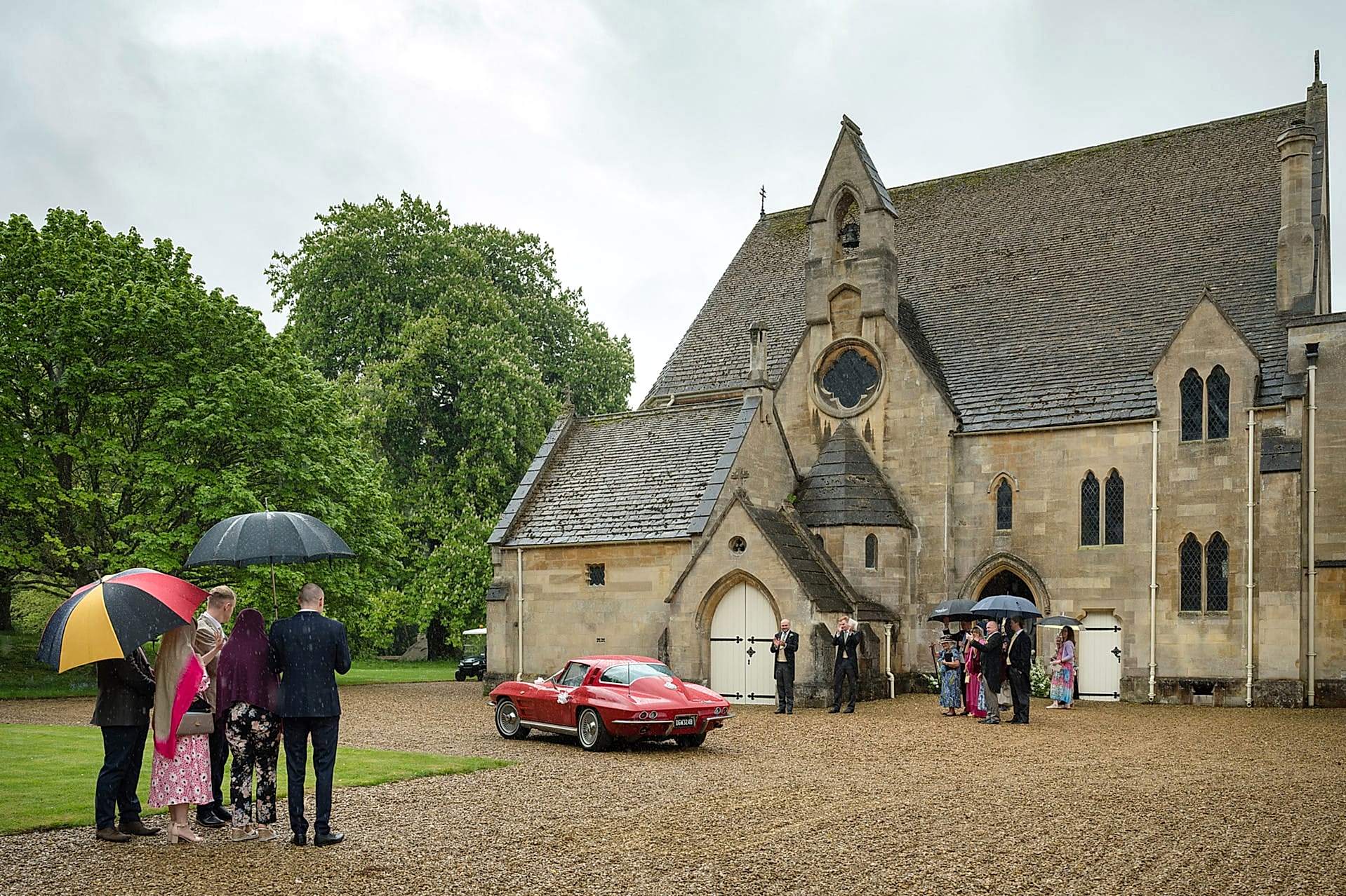 Wedding guests waving off the wedding car at Exton Park chapel