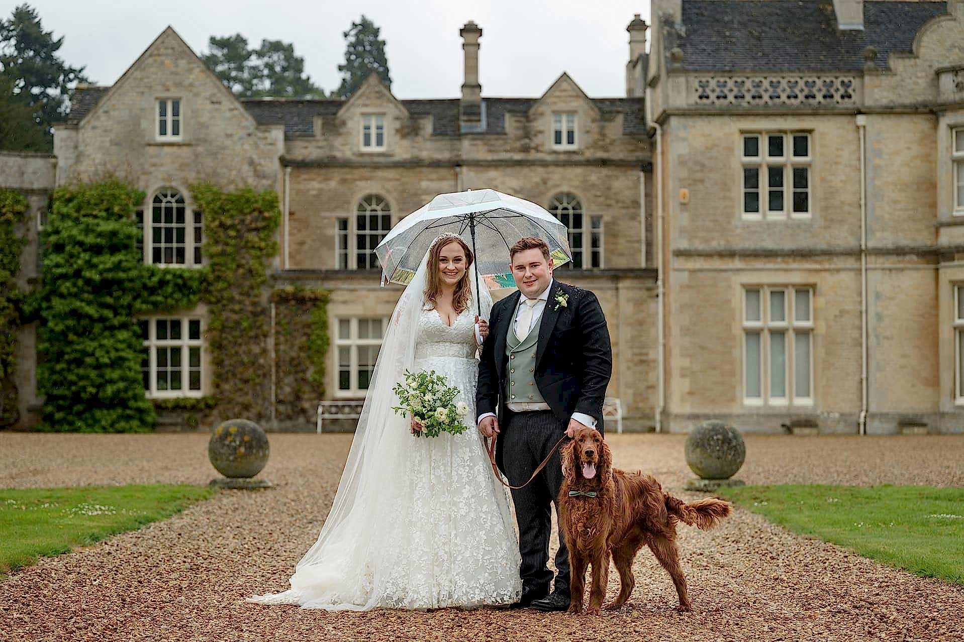 Bride and groom with their Irish red setter dog outside Exton Park Hall