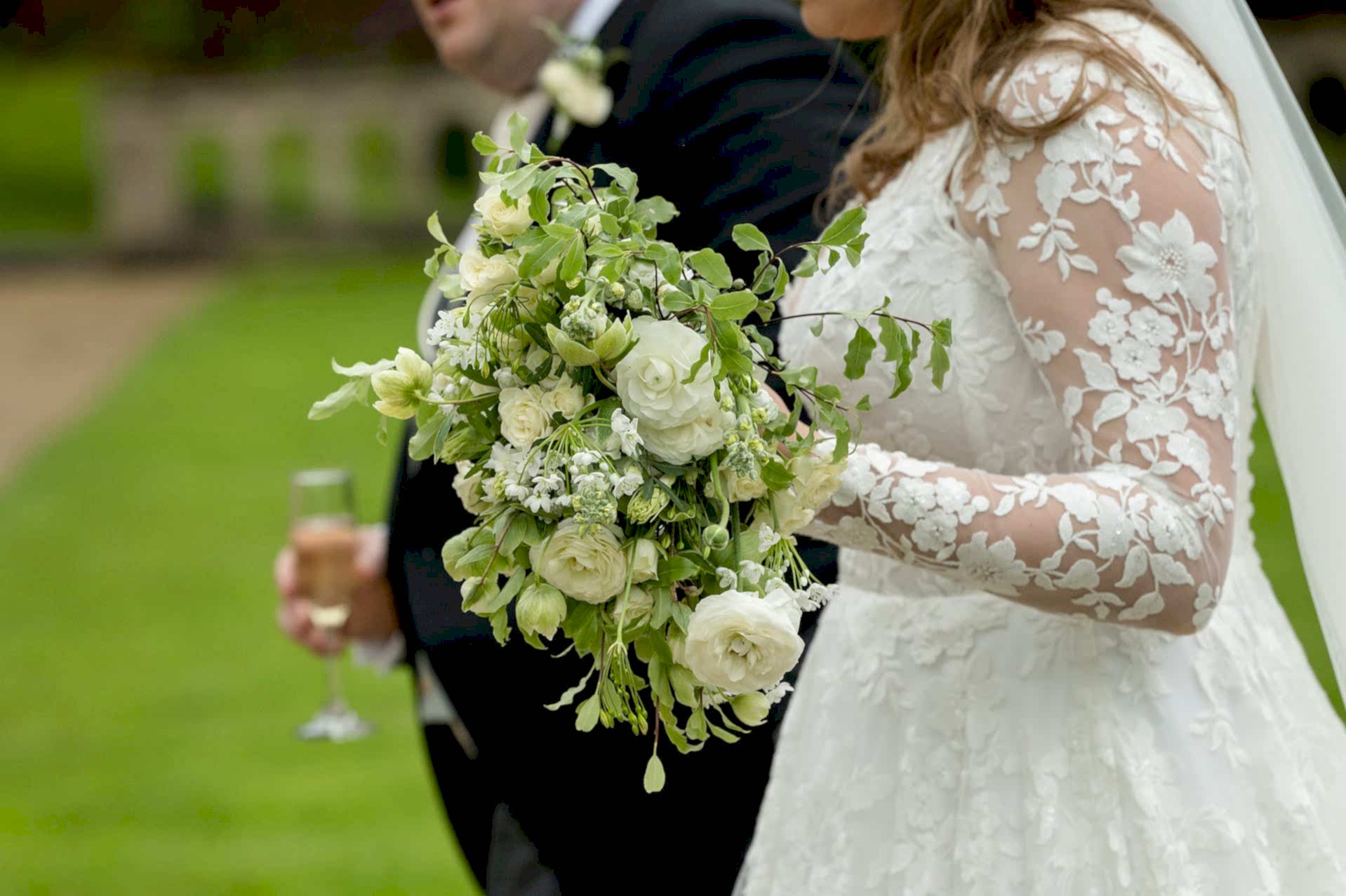 Close up photo of the bride's bouquet in her hand as she walks with the groom