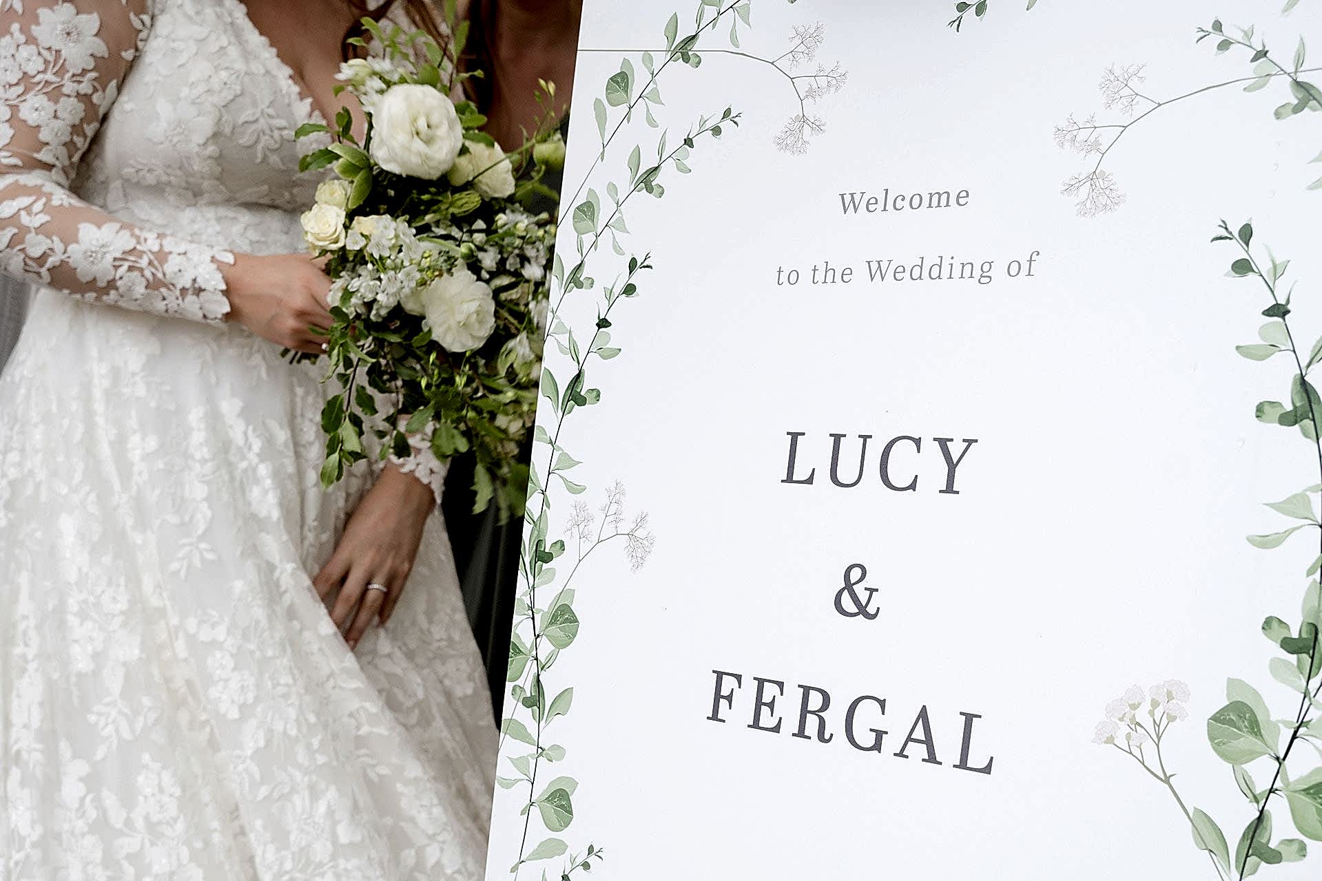 Close up photo of a section of the couple's wedding welcome sign with the bride and her bouquet in the background