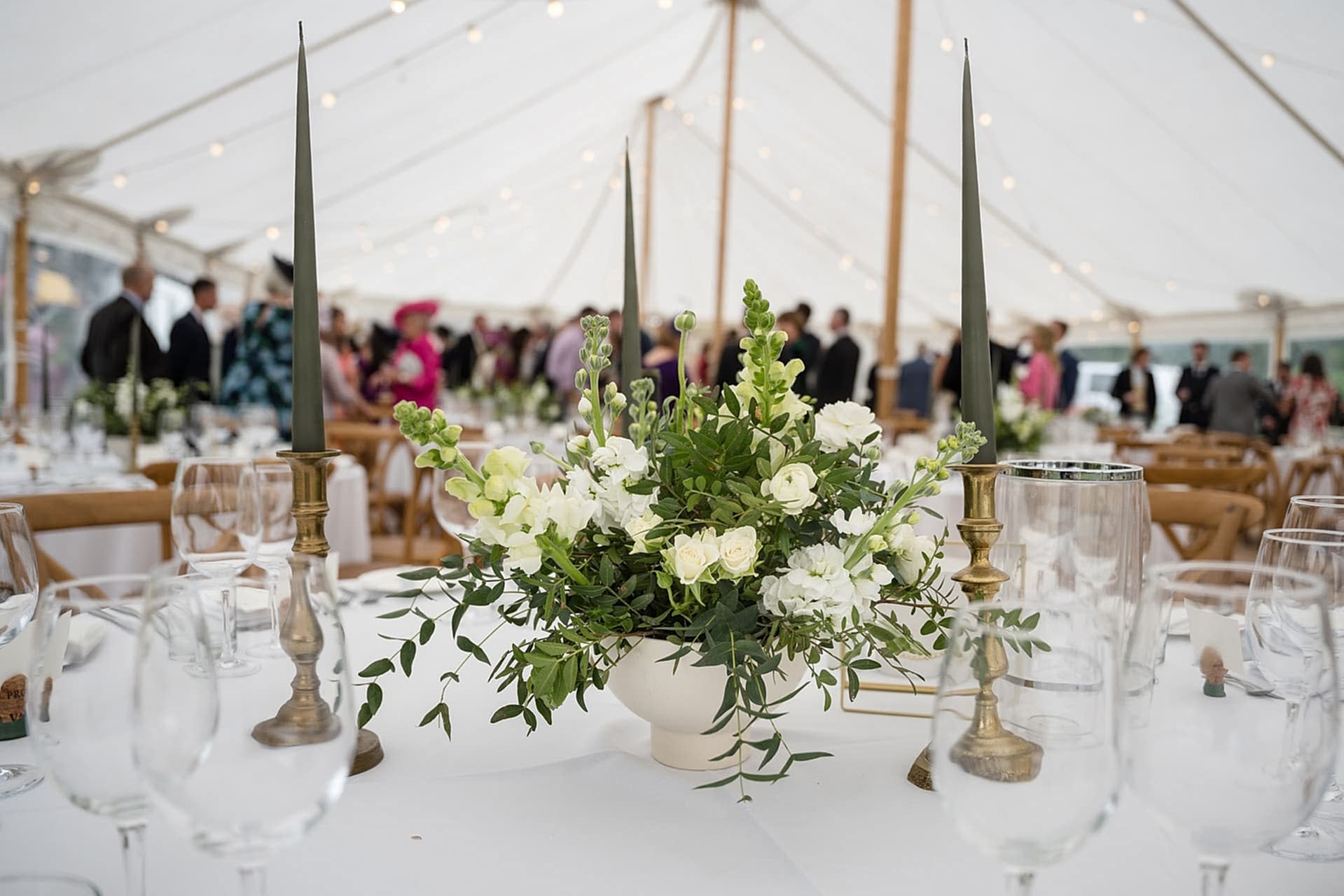 White flower and foliage table centre pieces for a marquee wedding