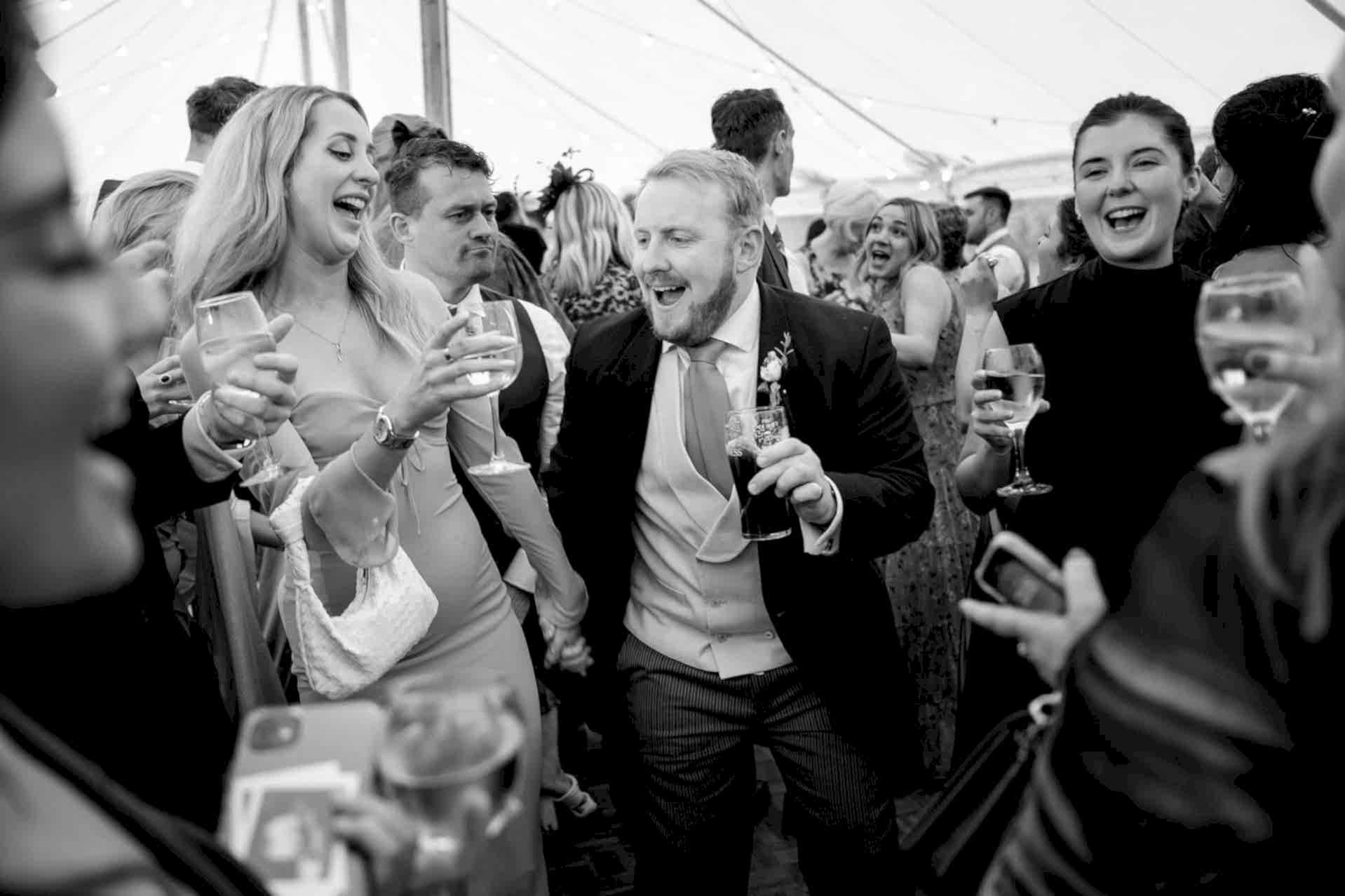 Wedding guests dancing and enjoying drinks