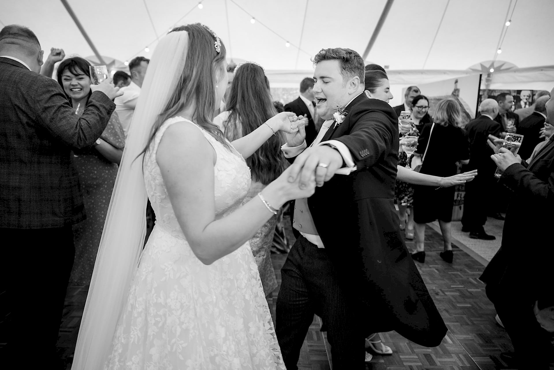 Bride and groom busting their moves on the dancefloor amongst their wedding guests