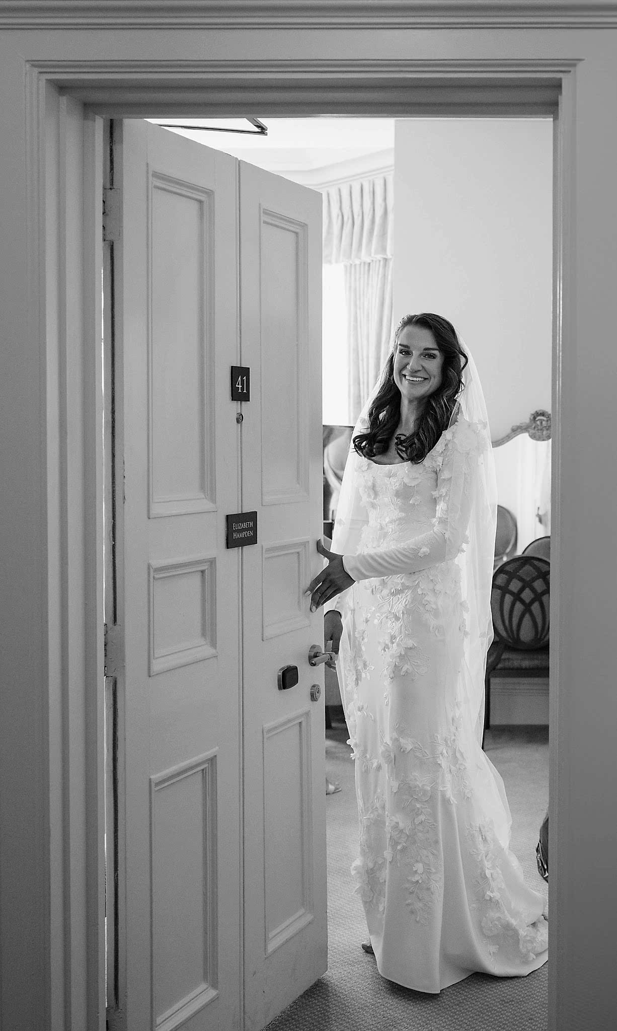 A bride looking through an open door to the wedding suite at Fawsley Hall