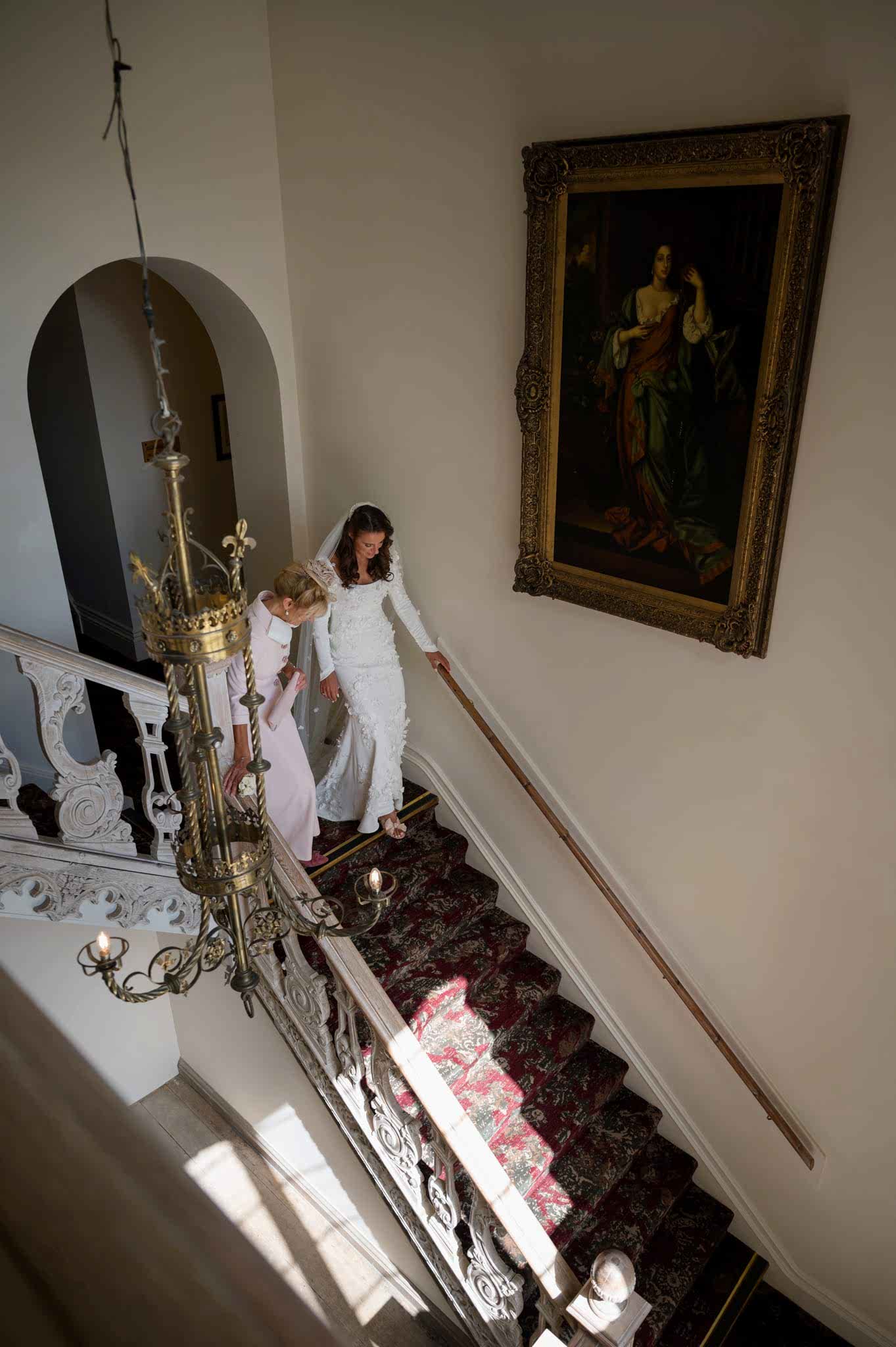 Bride and her mum going down a staircase at Fawsley Hall