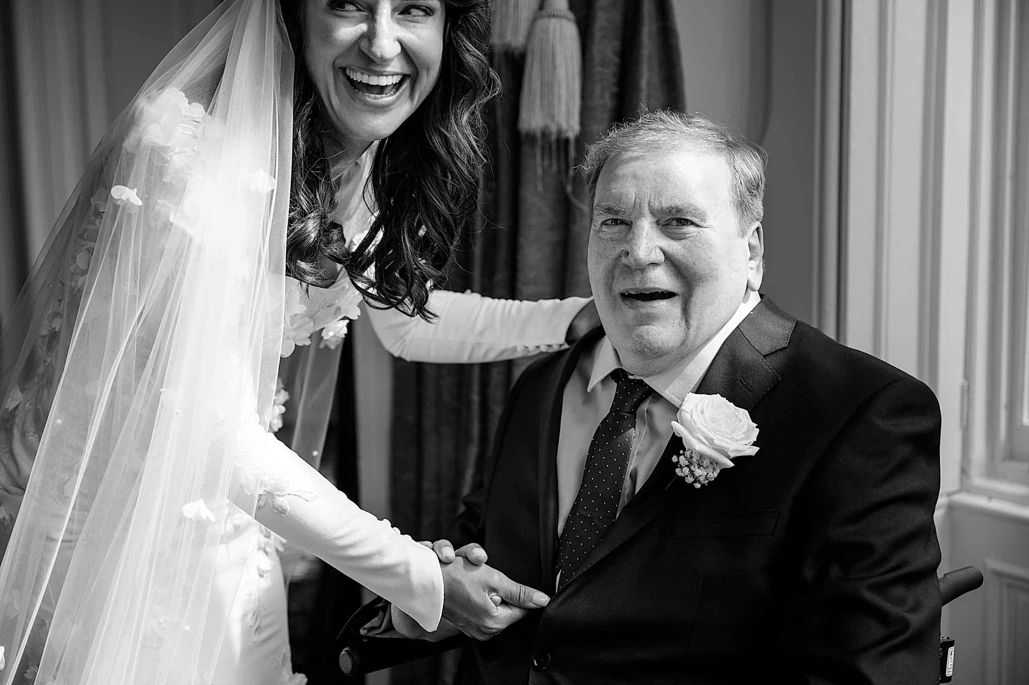 The bride and her dad laughing at their emotional reactions to him seeing her in her dress for the first time