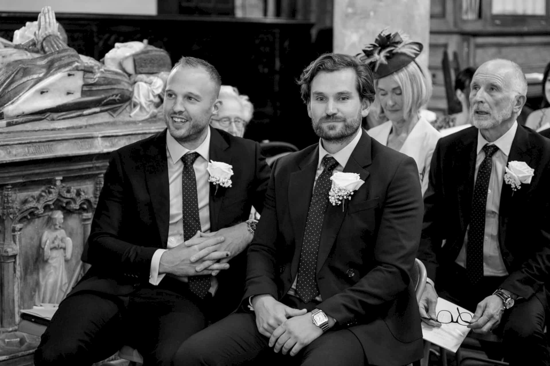The groom and his best man sitting in the pew, with his parents in the row behind, waiting for the bride to arrive