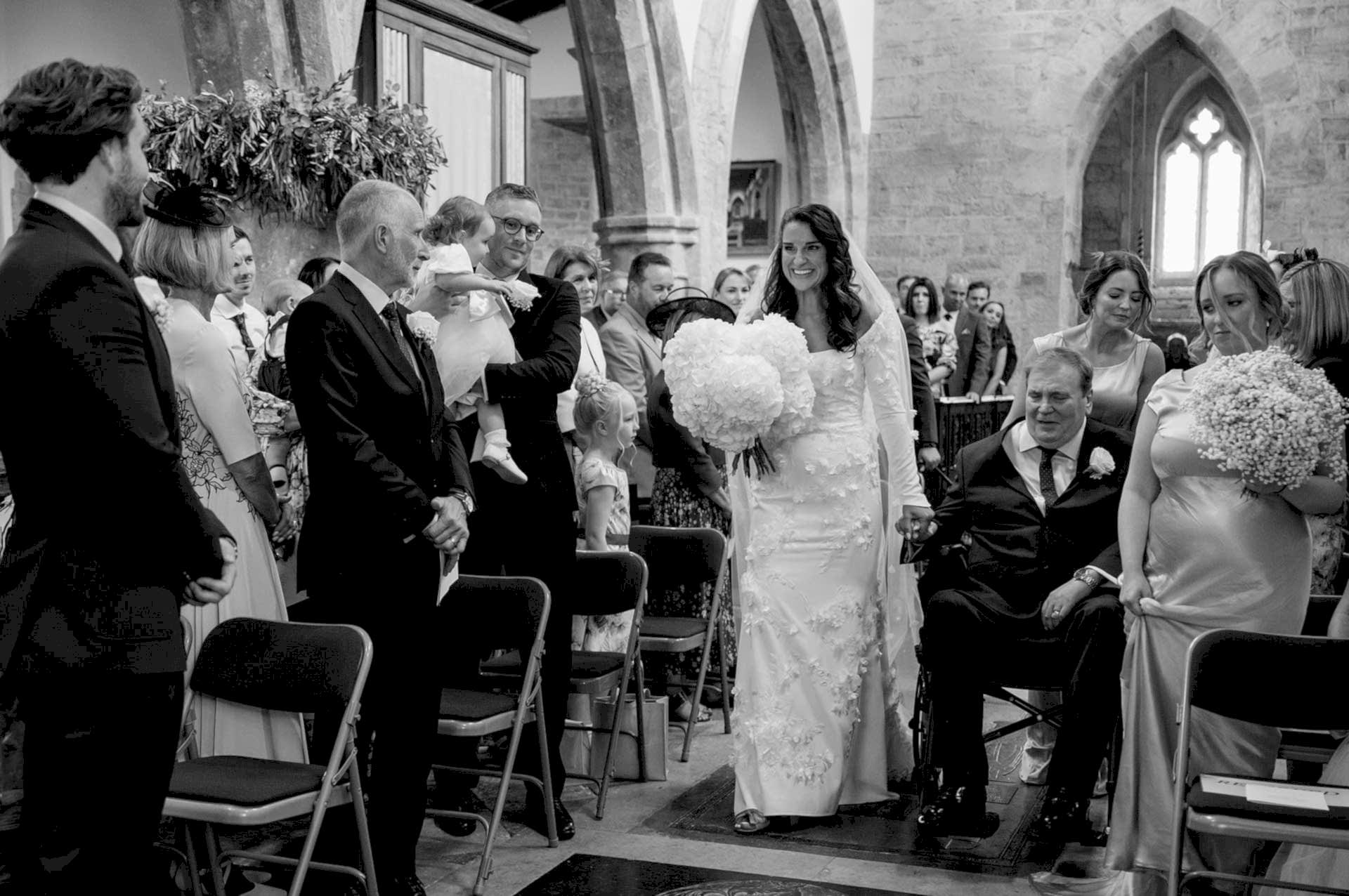 The bride and her dad making their entrance into Fawsley church