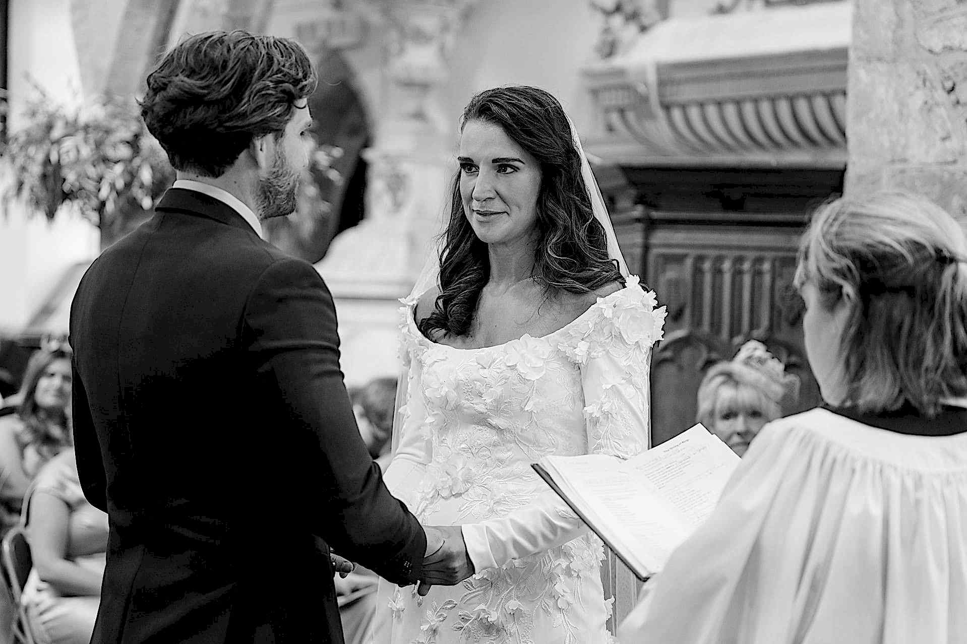 The bride and groom saying their marriage vows at Fawsley church