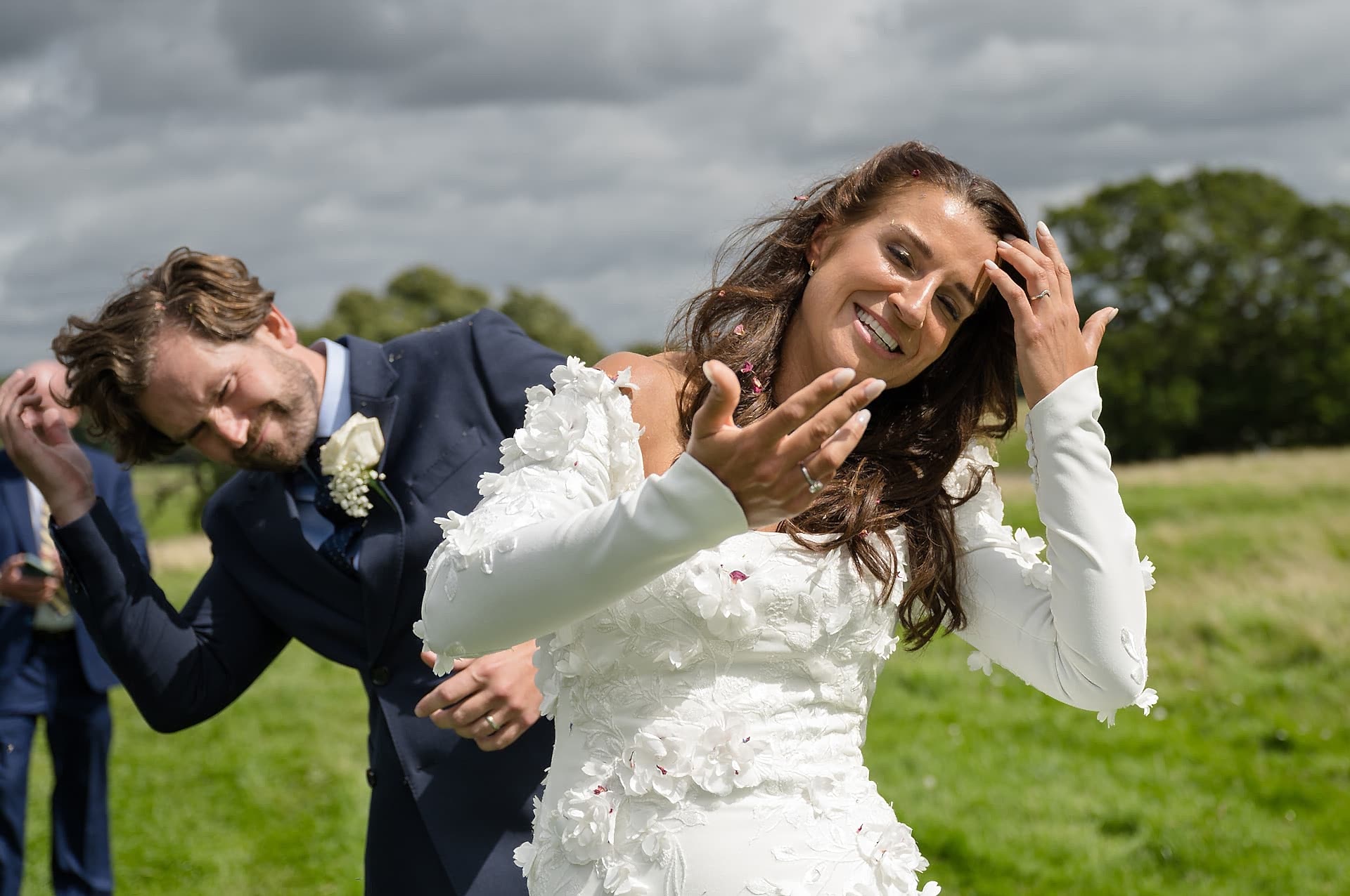 The bride and groom brushing confetti out of their hair