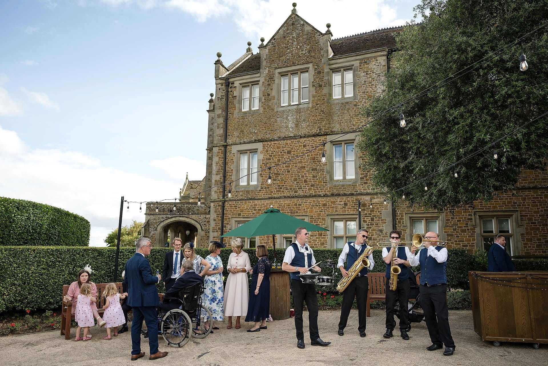 A marching band playing in front of Fawsley Hall