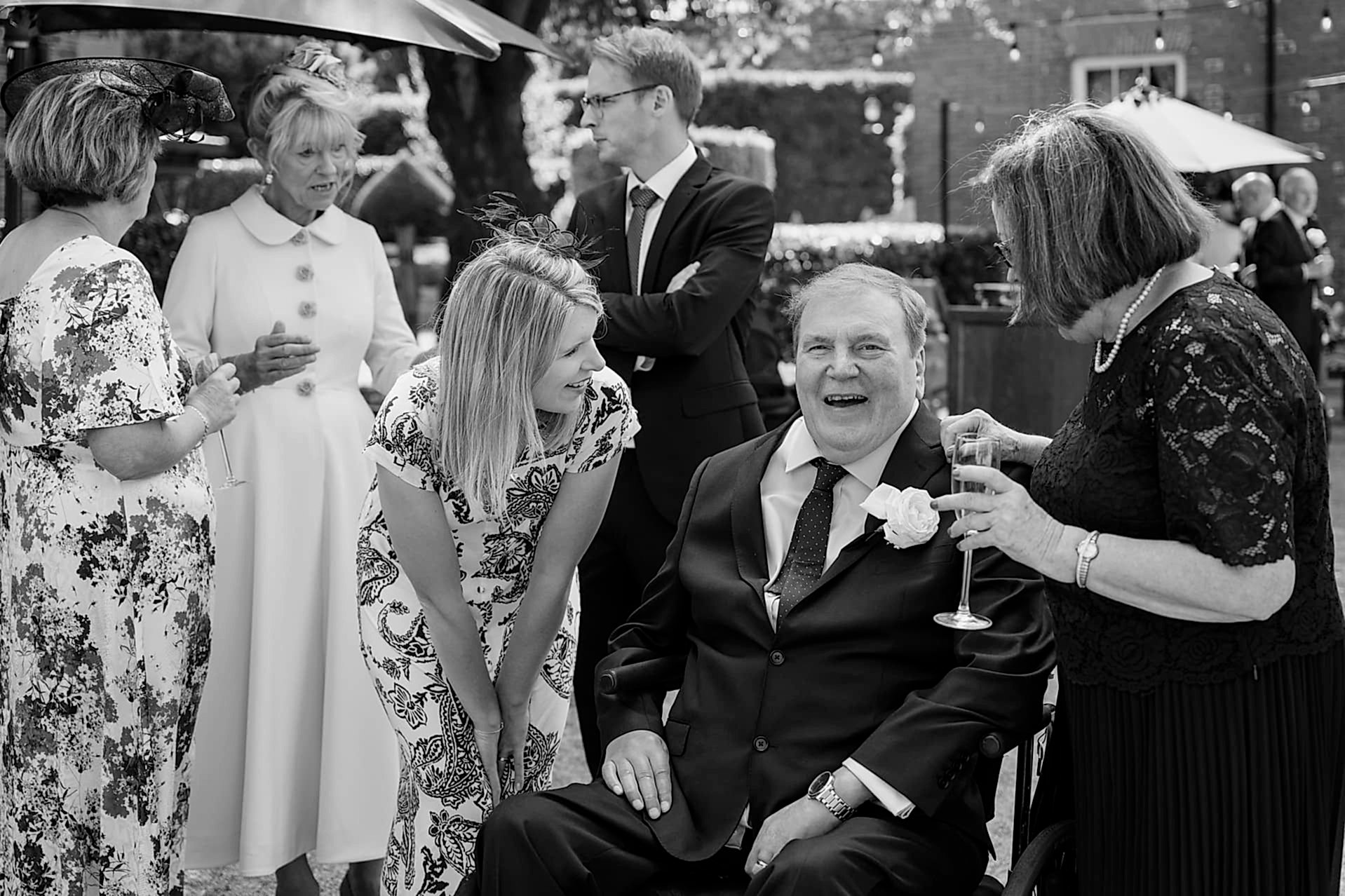 Wedding guests enjoying a wedding drinks reception outside Knightley Court at Fawsley Hall
