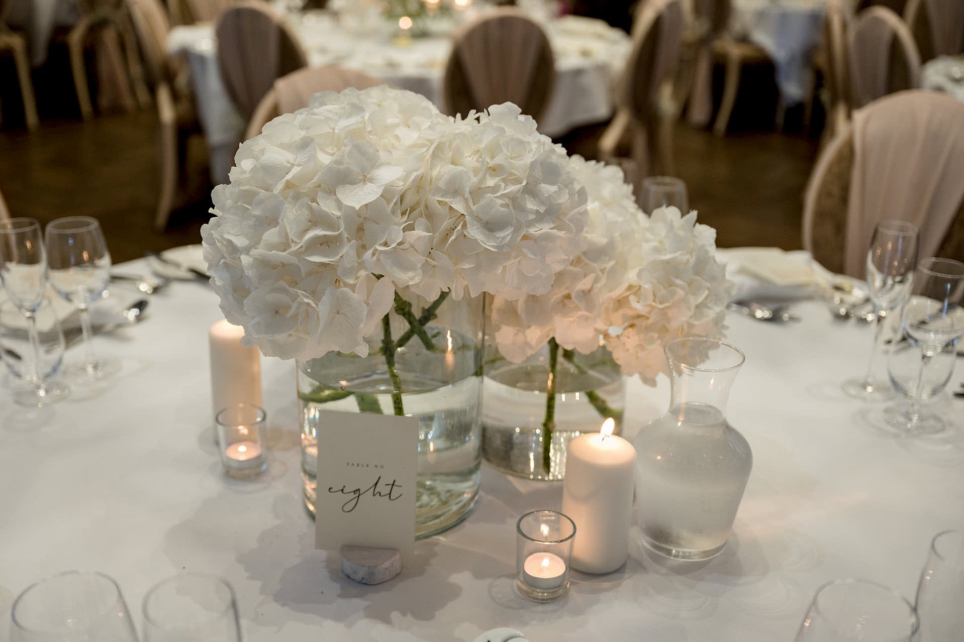 White hydrangea table centre pieces for a wedding breakfast in Knightley Court at Fawsley Hall
