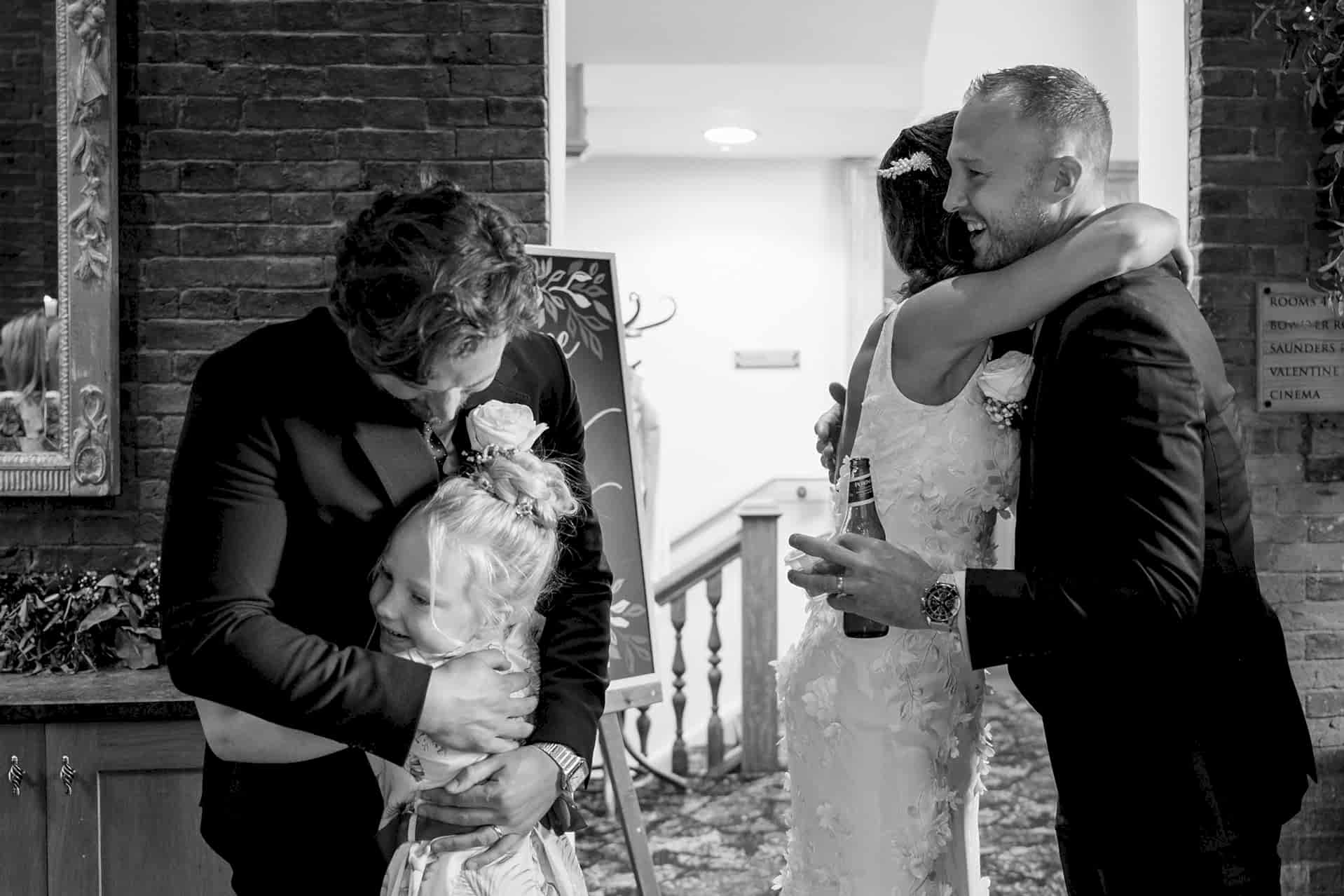 The bride and groom greeting wedding guests during the receiving line in Knightley Court at Fawsley Hall