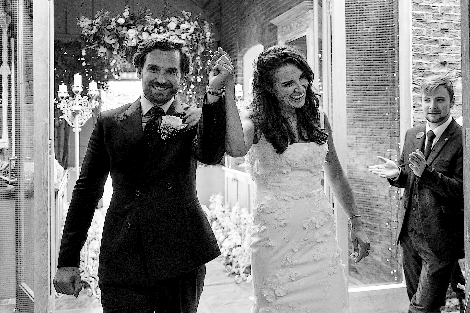 The bride and groom triumphantly entering the dining room at Knightley Court for their wedding breakfast