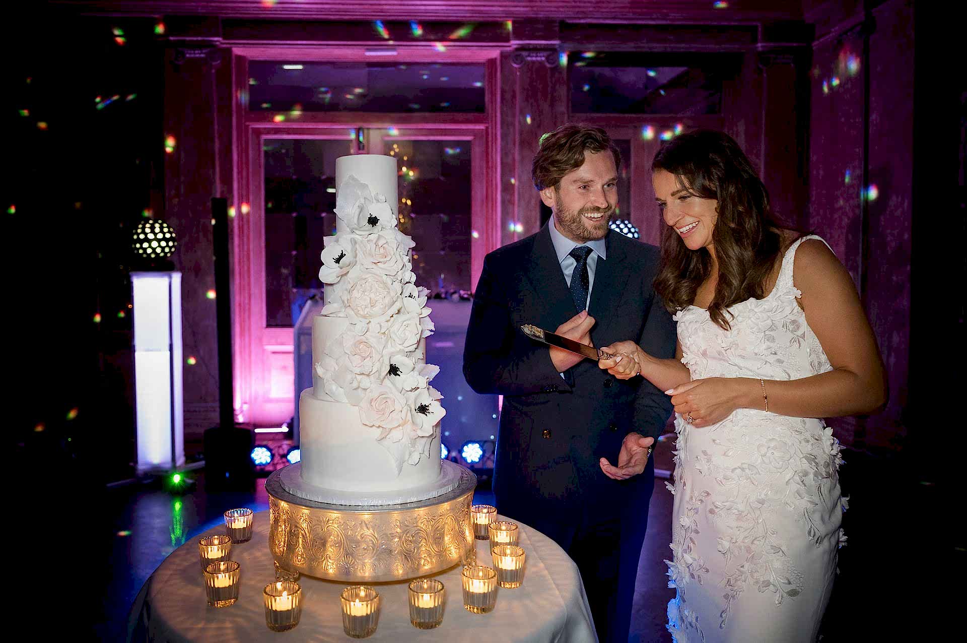The bride and groom holding a knife ready to cut their wedding cake