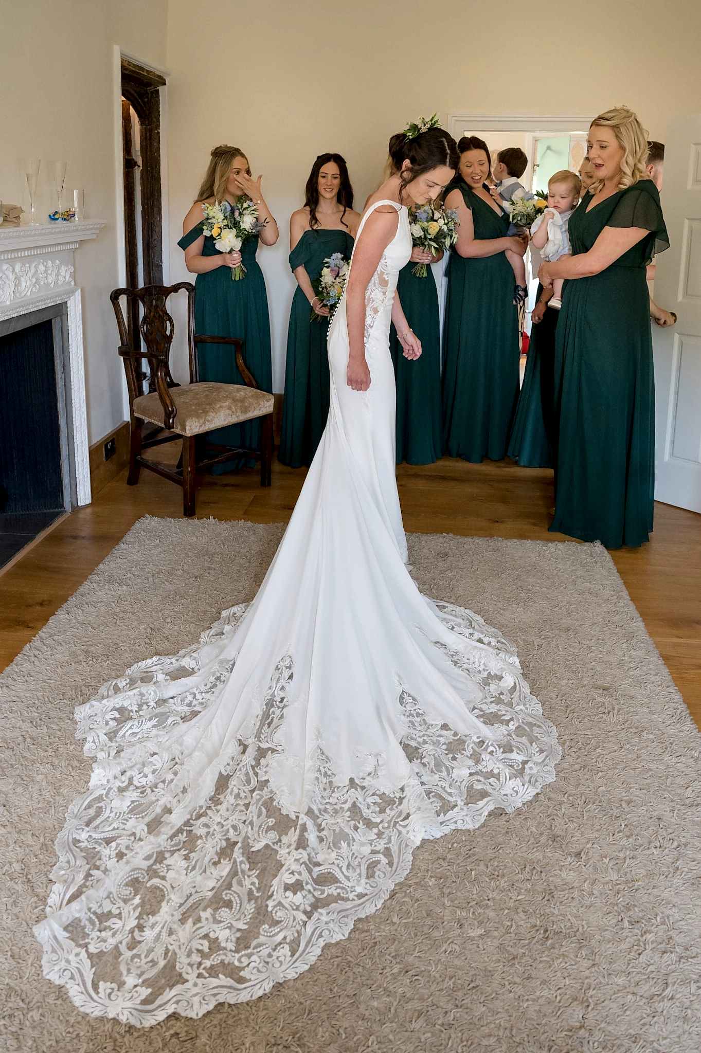 Bridesmaids looking at the bride's dress