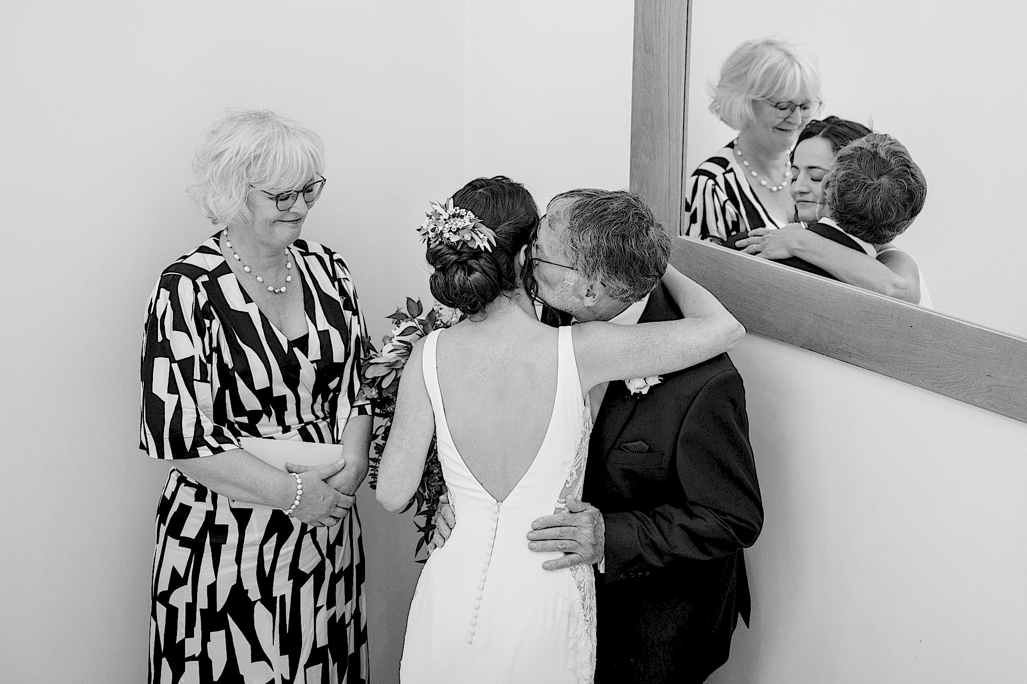 Bride's dad giving her a kiss on the cheek as he sees her in her dress for the first time