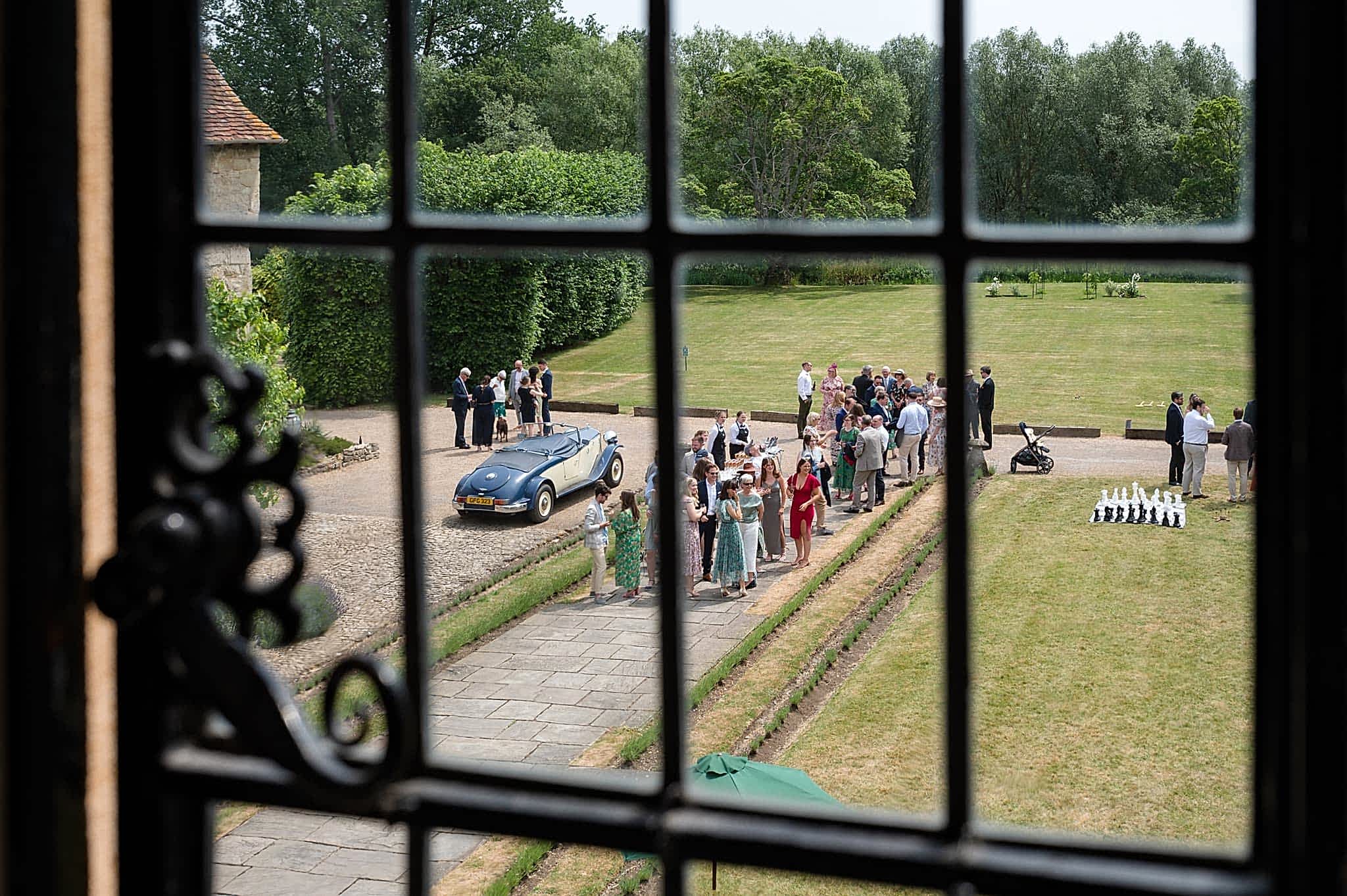 View through an upstairs window of wedding guests arriving at Notley Abbey