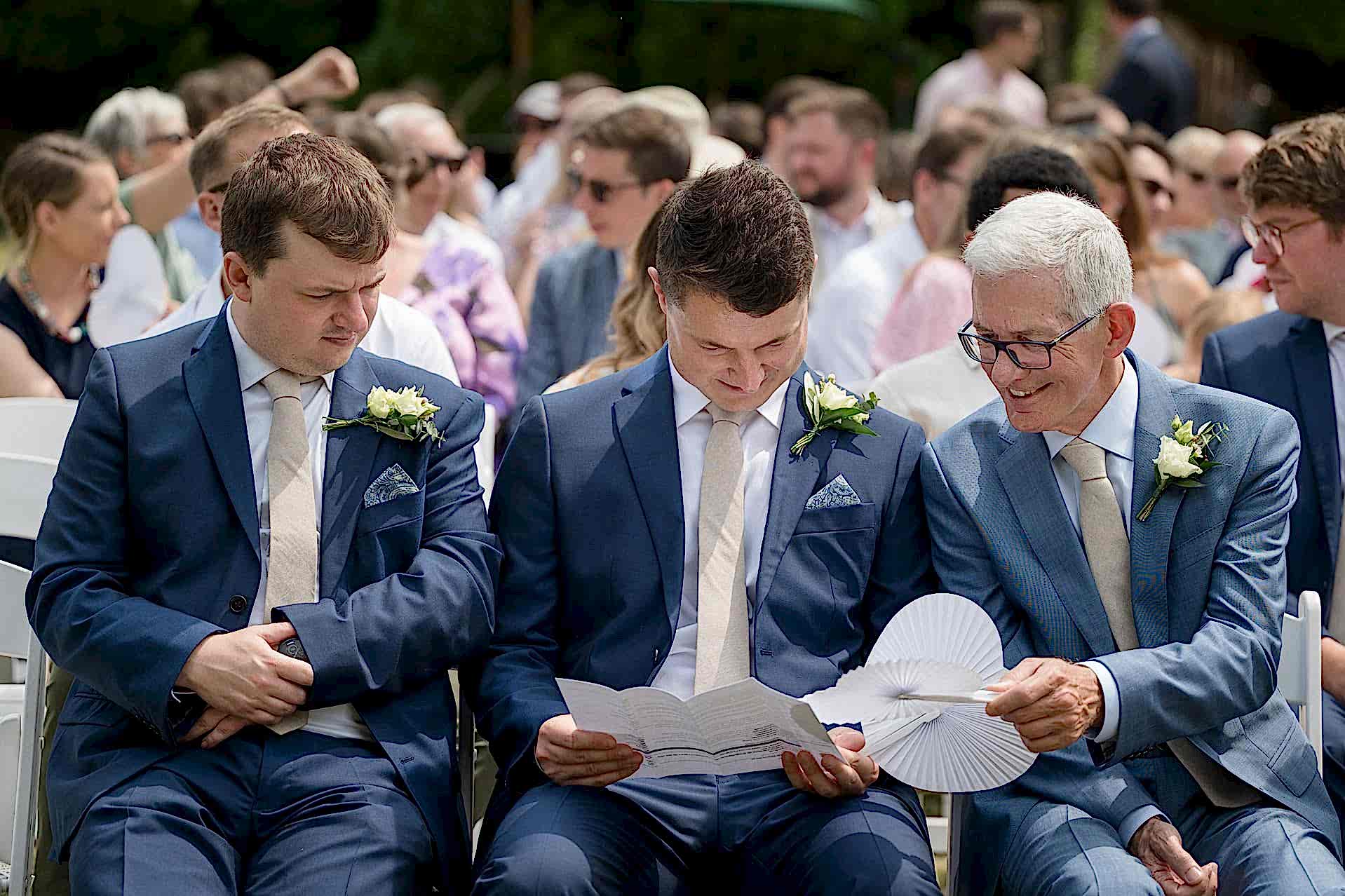 Two ushers and the groom's dad chatting before the ceremony starts