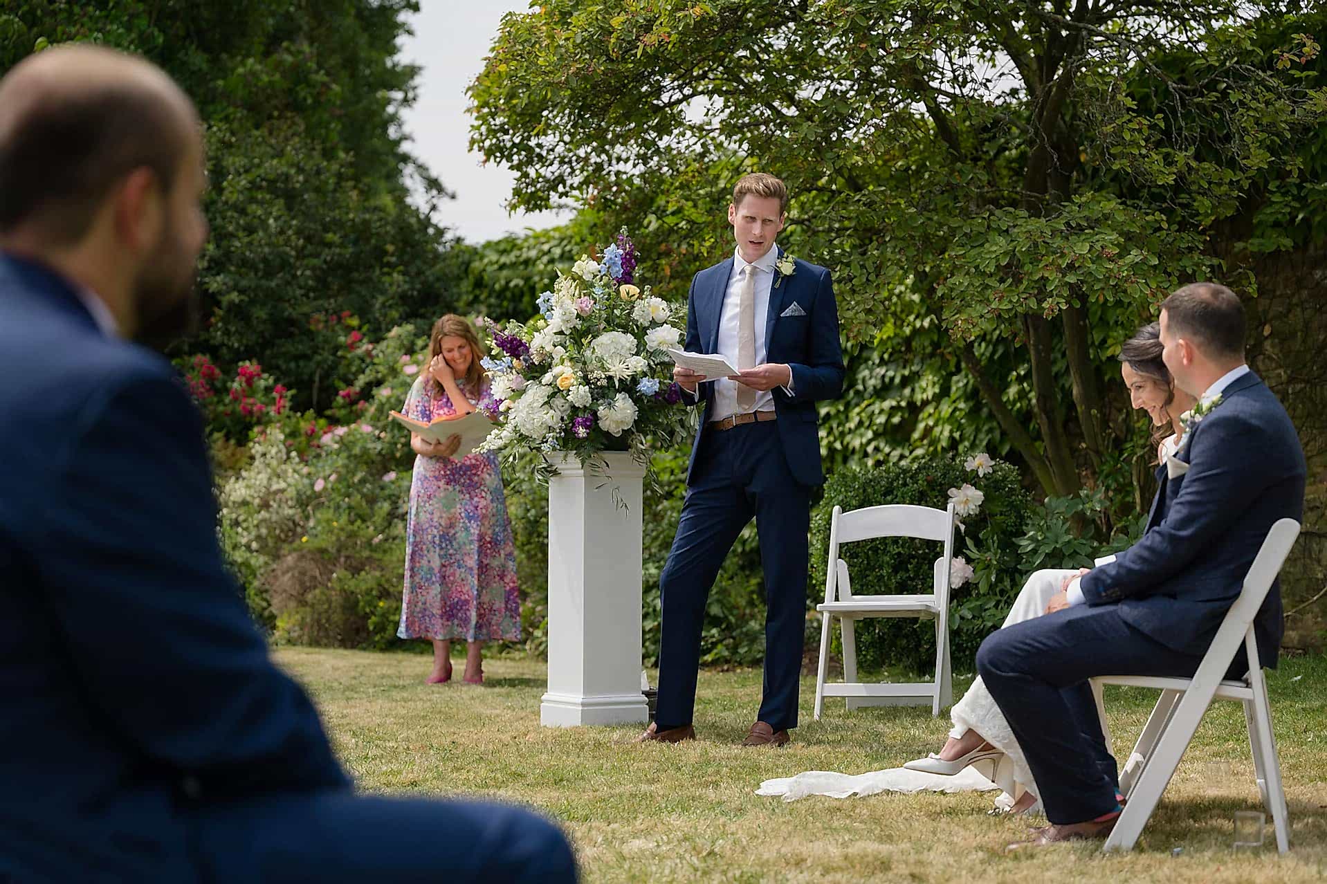 An usher doing a reading during a ceremony in the walled garden at Notley Abbey