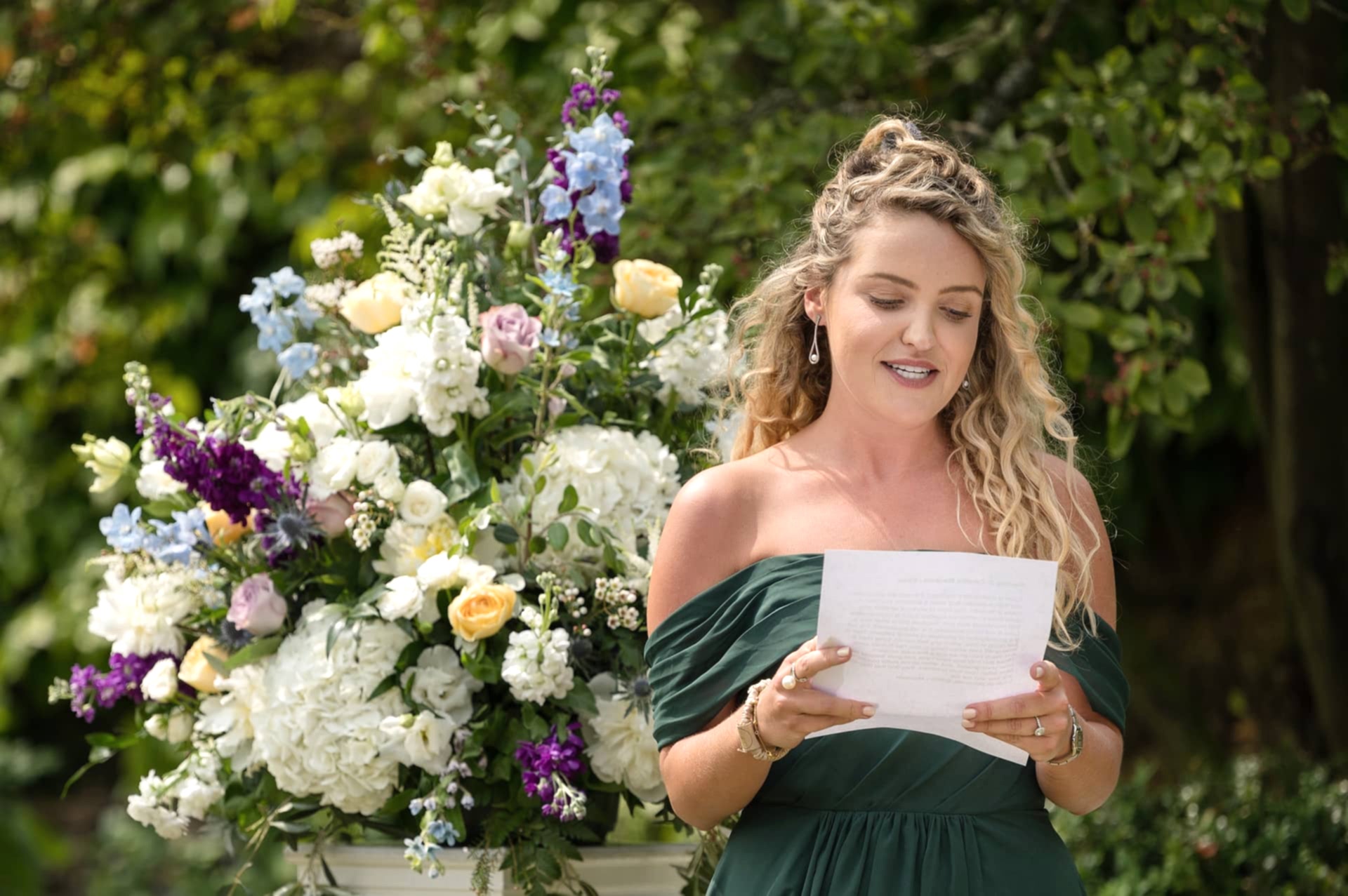 A bridesmaid doing a reading for an outdoor wedding ceremony at Notley Abbey