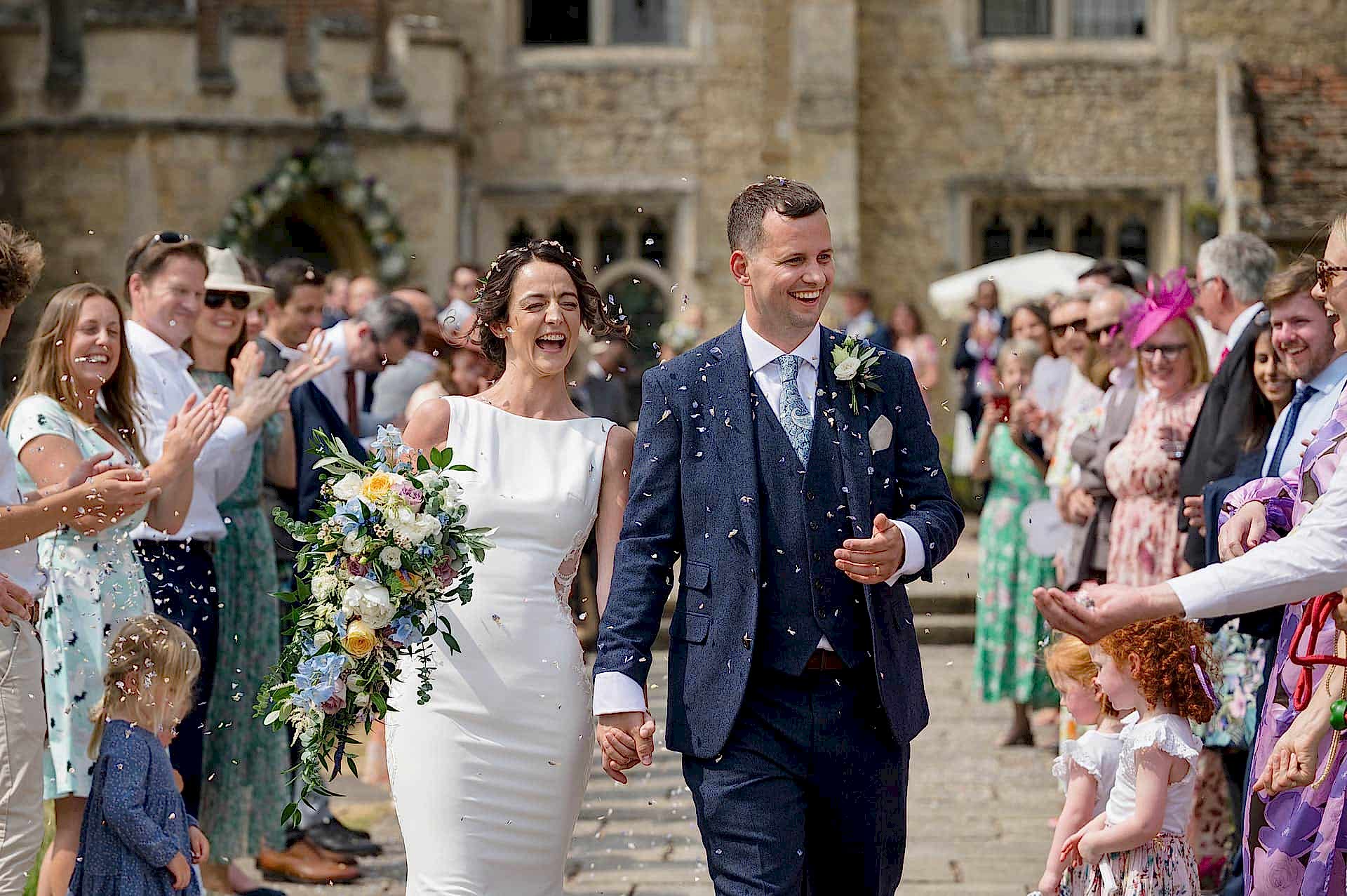 The bride and groom being covered in confetti at Notley Abbey