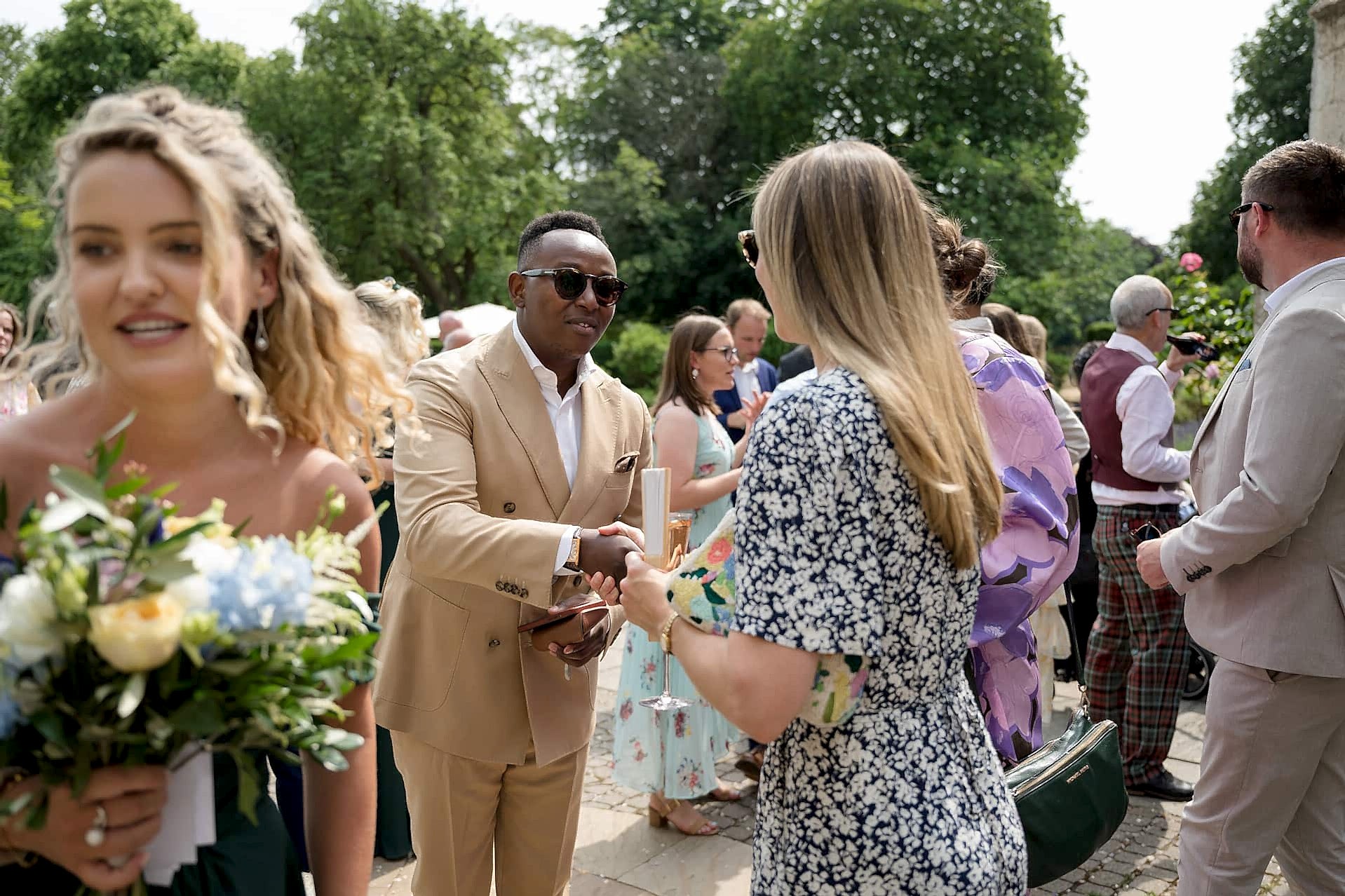 Wedding guests chatting during the drinks reception outside at Notley Abbey