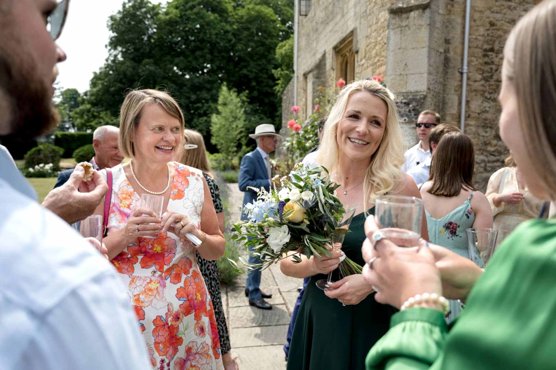 Wedding guests chatting during the drinks reception outside at Notley Abbey