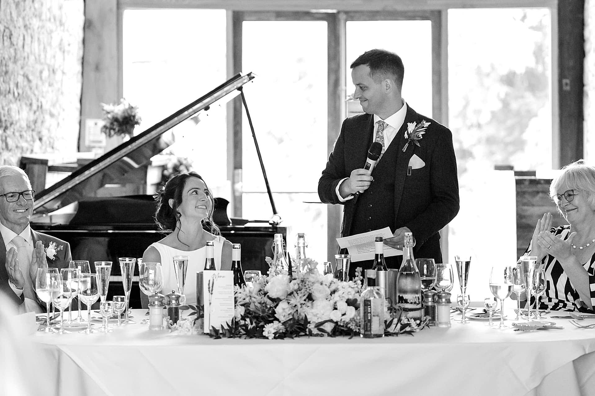 The groom speaking to the bride during his speech