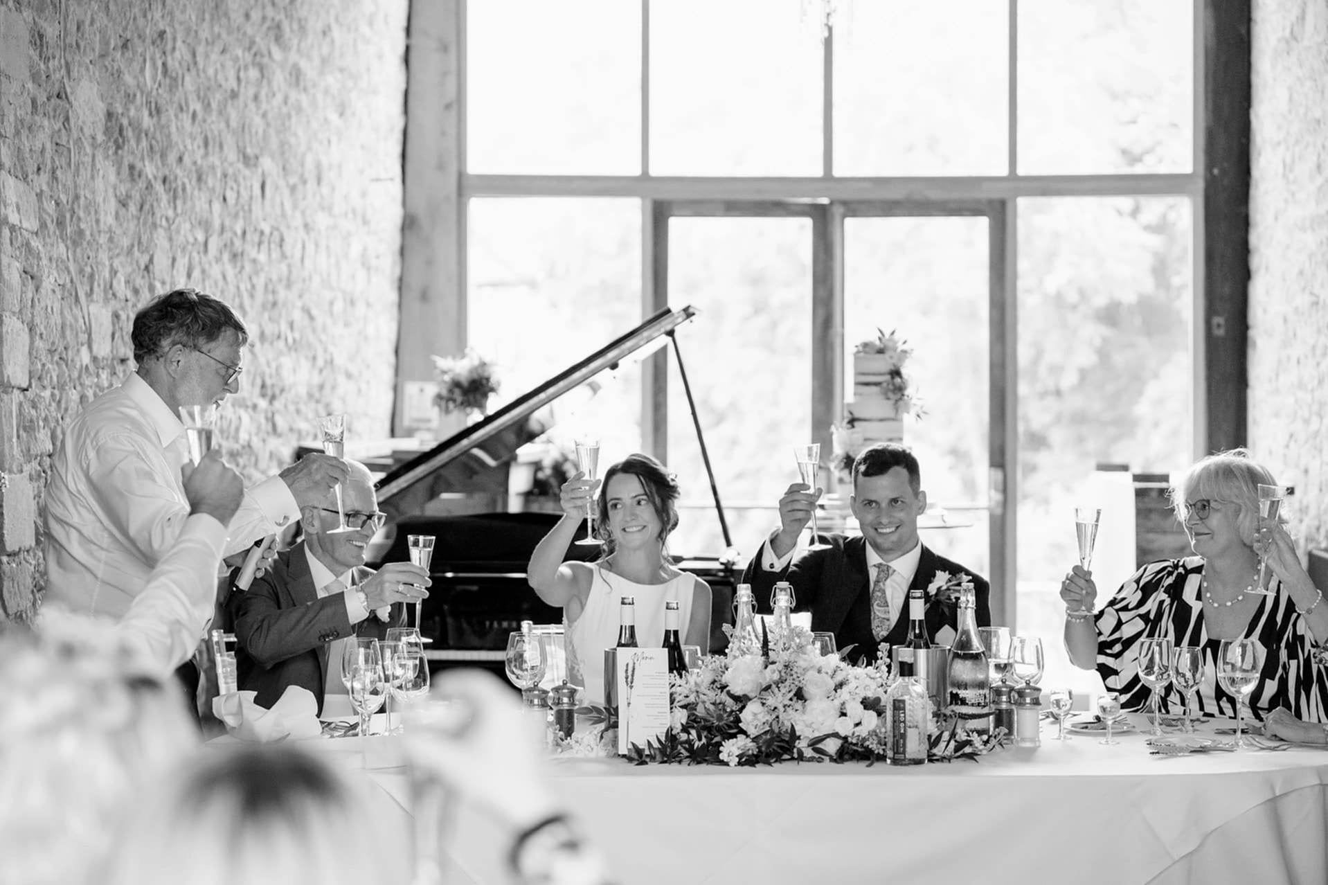 The bride, groom and their parents toasting at the end of the bride's dad's speech