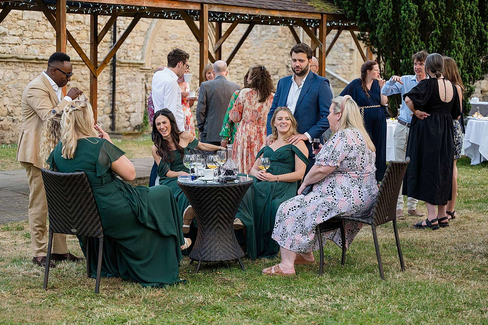 Wedding guests sitting outside in the courtyard after dinner at Notley Abbey