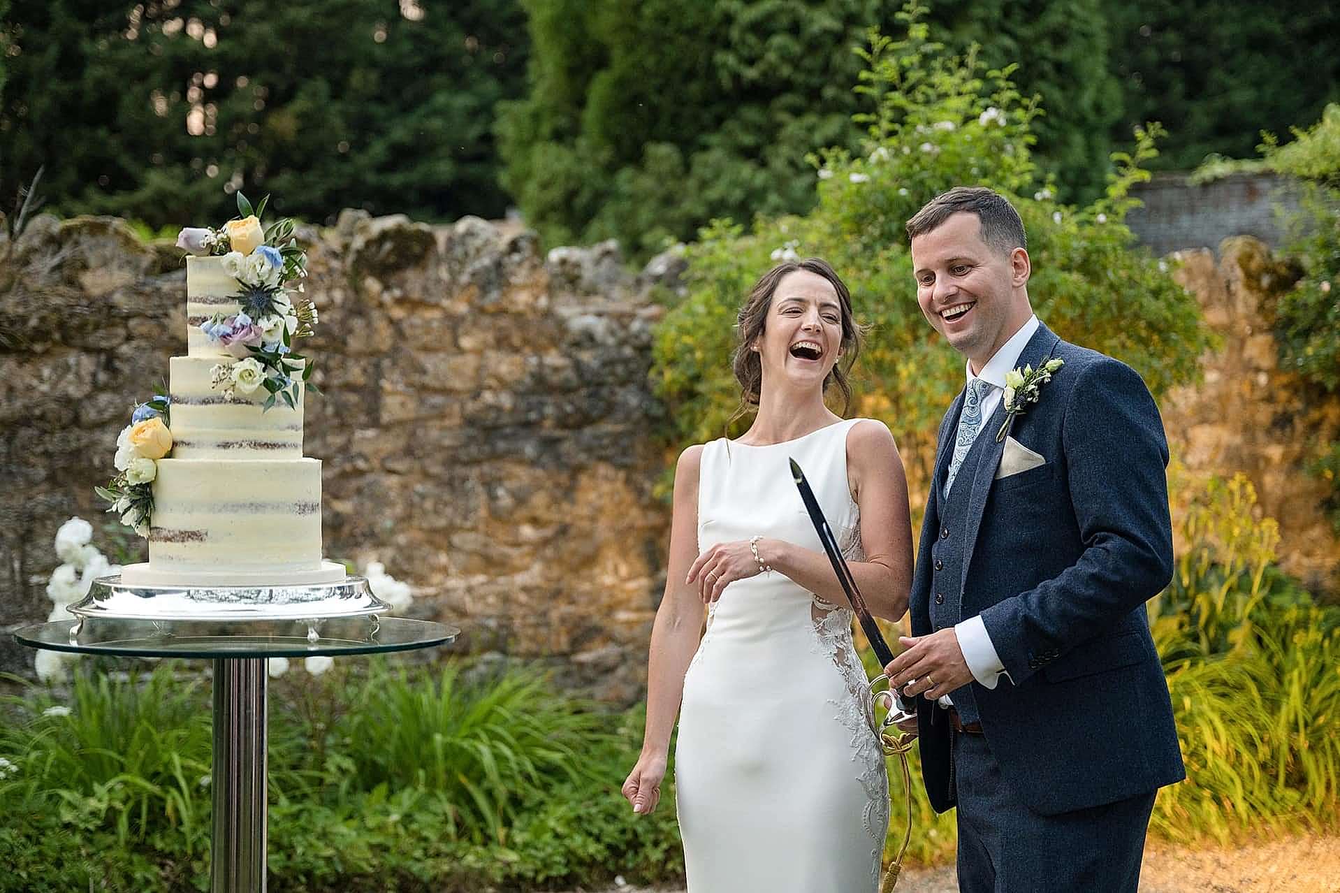 Bride laughing at the groom after he licked icing off the sword they used to cut their wedding cake
