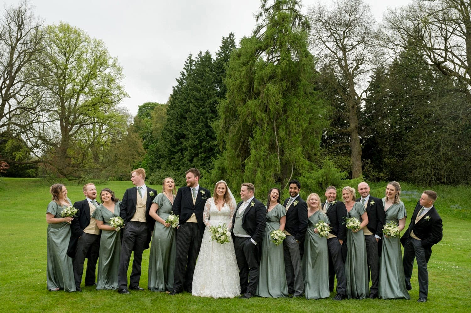 A group photo of 16 bridesmaids and groomsmen at Exton Park