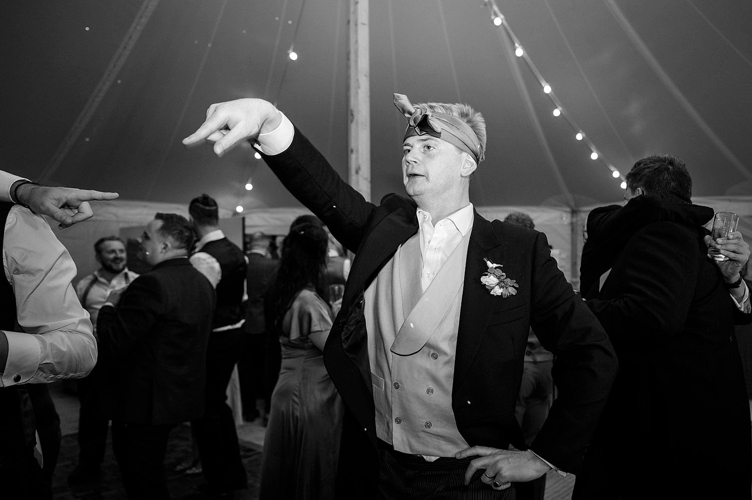 Usher at a wedding with tie on head and showing off their dance moves